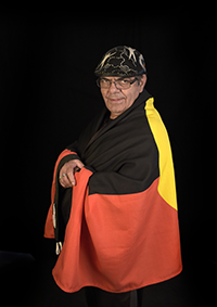 Uncle Boots with the Aboriginal Flag wrapped around him