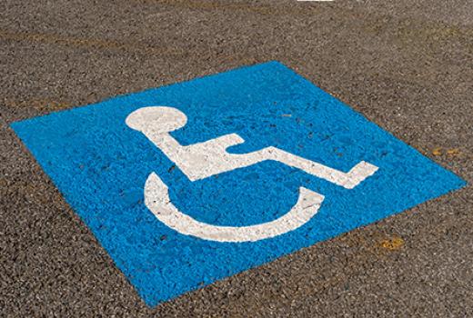 Accessible parking symbol painted on asphalt